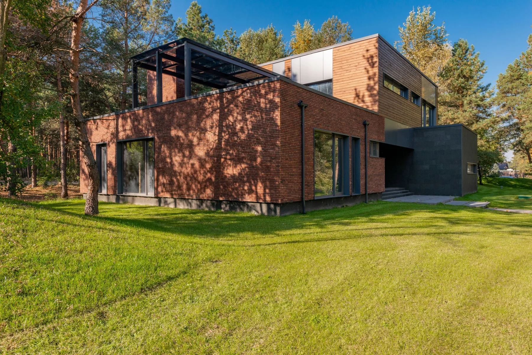 Contemporary brick home framed by lawn and mature trees