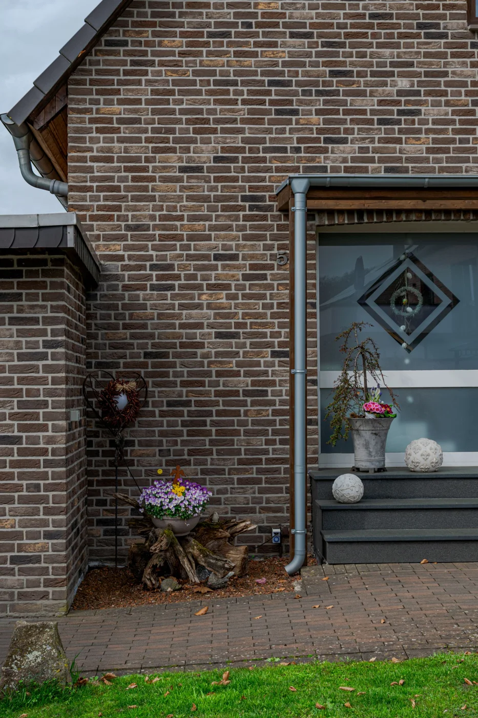 Brick house entrance with paving and potted plants