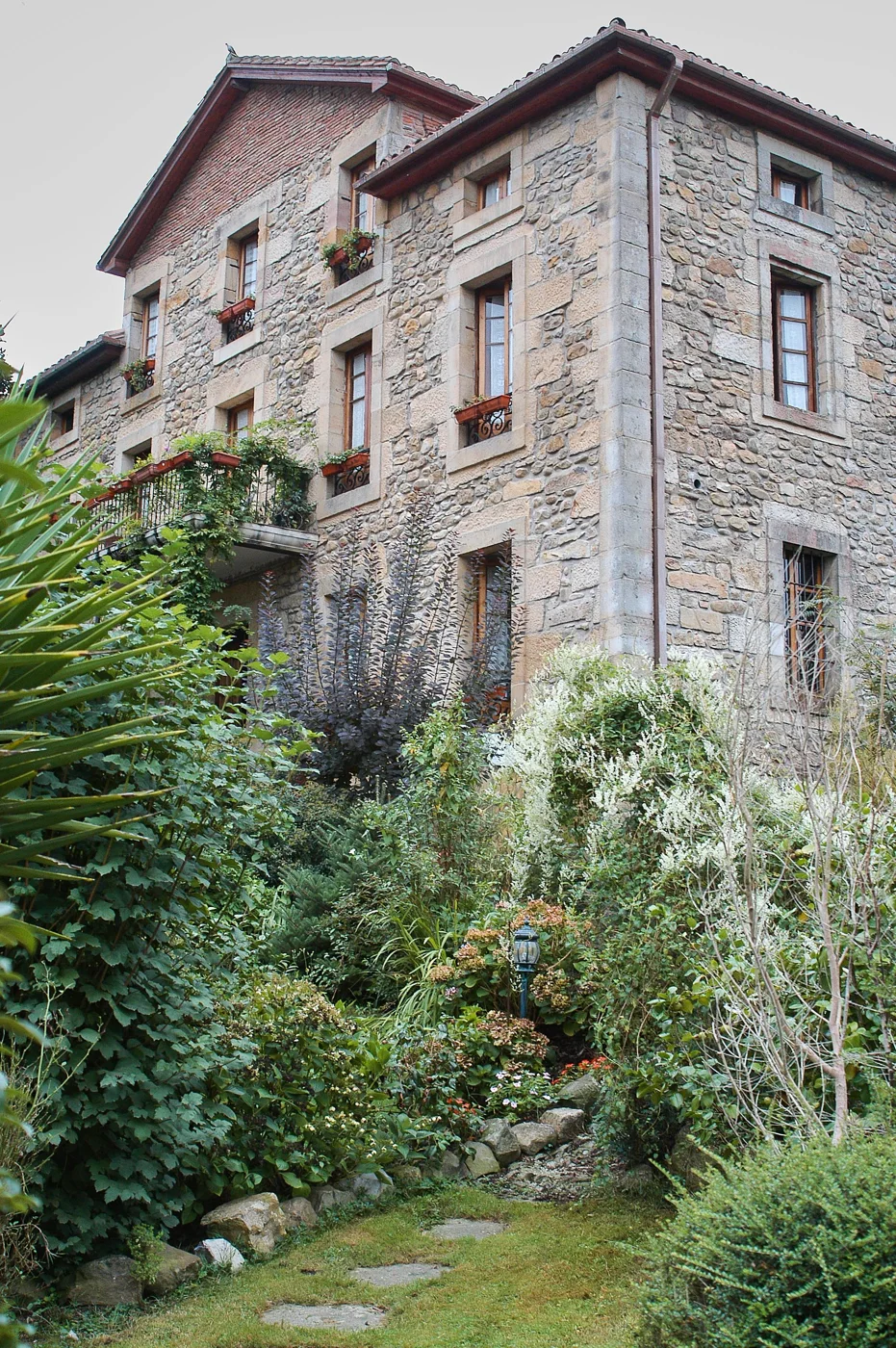 Natural stone architecture softened by a lush planted garden